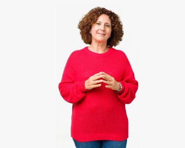 Güzel orta ager üst düzey kadın kırmızı kış kazak üzerinde arka plan eller birlikte izole ve rahat ve neşeli gülümseyen parmak çarpı işareti. Başarı ve iyimser