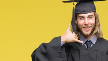 Genç yakışıklı mezun uzun saçlı adam yapıyor gülümseyen izole arka plan üzerinde telefon hareketi ile el ve parmak telefonda konuşuyor gibi. Kavramları iletişim.