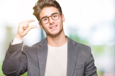 İzole arka plan gülümseyen ve boyutu işaret parmaklı ararken ve kamera işi el ile kendinden emin eller üzerinde gözlük takan genç iş adamı. Ölçü kavramı.