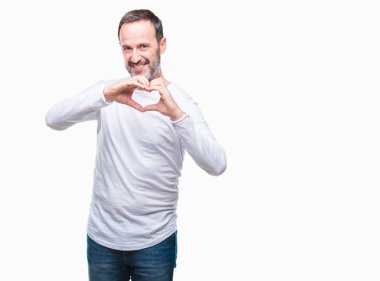 Kalp simgesi ve elleriyle şekil gösterilen aşık gülümseyen izole arka plan üzerinde beyaz t-shirt giyen orta yaş ağarmış komuta sizde. Romantik kavramı.