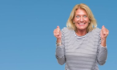 Orta yaş sarışın kadın izole arka kolları olan başarı için heyecan üzerinde zafer kutluyor gülümseyen kaldırdı. Kazanan kavramı.