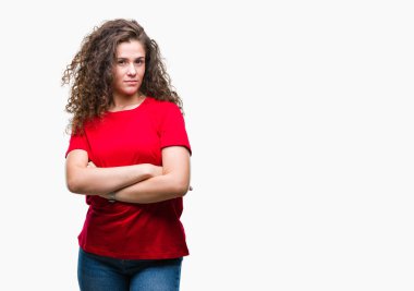 Kameraya bakarak çapraz silah ile gülümseyen izole arka plan mutlu yüzüne rahat bakmak giyen güzel esmer kıvırcık saçlı Genç kız. Olumlu bir kişi.