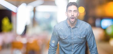 Genç yakışıklı adam korkuyor ve şok sürpriz ifade ile izole arka plan üzerinde korku ve yüz heyecanlı.