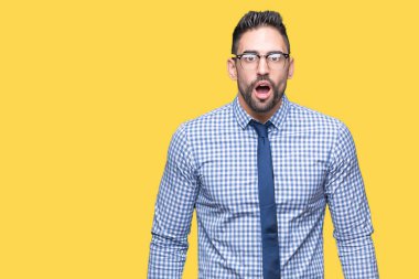 Korkuyor ve şok sürpriz ifade, korku ve heyecan yüz ile izole arka plan üzerinde gözlük takan genç iş adamı.