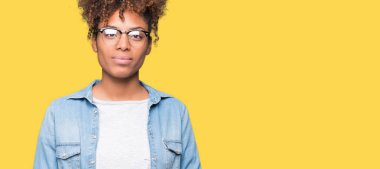 Güzel genç Afro-Amerikan kadın üzerinde gözlük takan birlikte arka plan eller izole ve rahat ve neşeli gülümseyen parmak çarpı işareti. Başarı ve iyimser