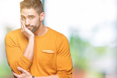 İzole arka plan düşünme seyir üzerinde genç yakışıklı adam yorgun ve sıkılmış çapraz silah depresyon sorunları ile.