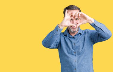 İzole arka plan yaparken kalp şekli ile el ve parmak işareti seyir gülümseyen yakışıklı orta yaş zarif üst düzey adam