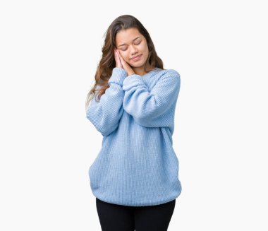 Uyku yorgun hayal ve ile gülümseyen gözleri kapalı iken ellerle birlikte poz izole arka plan üzerinde mavi kış kazak giyen genç güzel esmer kadın.