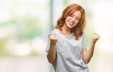 Gülümseyen ve başarı için çığlık genç güzel kadın izole arka plan çok mutlu ve heyecanlı kaldırdı, silah ile kazanan jest yapıyor. Kutlama kavramı.