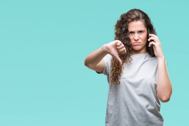 Genç esmer kız Smartphone'da kızgın yüzü, eksi işareti aşağı antipati başparmak ile gösterilen, ret kavramı ile izole arka plan üzerinde konuşuyor