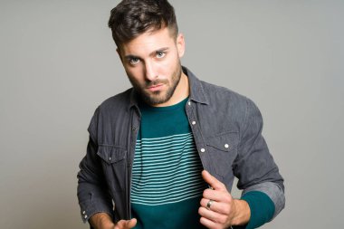 Yakışıklı delikanlı possing ve modelleme gri izole arka plan üzerinde