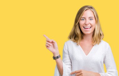 Yüzünde kocaman bir gülümseme ile izole arka plan üzerinde güzel genç zarif kadın kameraya bakarak yan el ve parmak ile işaret.