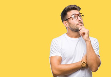 Çene düşünme hakkında soru, dalgın ifade üzerine el ile izole arka plan üzerinde gözlük takan yakışıklı delikanlı. Düşünceli yüzüyle gülümsüyor. Şüphe kavramı.