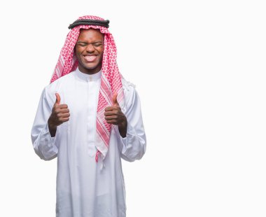 Geleneksel keffiyeh izole arka kolları olan başarı için heyecan üzerinde giyen genç Arapça Afrika adam zafer kutluyor gülümseyen kaldırdı. Kazanan kavramı.