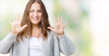 Parmakları ile number ten kendinden emin ve mutlu gülümseyerek süre güzel artı boyutu genç kadın giyiyor kış ceket ve yukarıyı gösteren izole arka plan üzerinde.