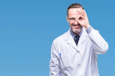 Orta yaş üst düzey ağarmış profesyonel adam gülümsüyor, parmakları ile mutlu yüz üzerinden seyir göz el ile ok jest yapıyor izole arka plan üzerinde beyaz önlük giyiyor.