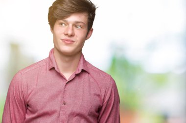 Genç yakışıklı iş adamı görünümlü yan ve dik dik bakma uzağa düşünce gülümseyen izole arka plan üzerinde.