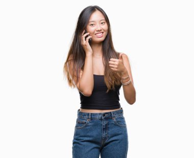 İzole arka plan üzerinde mutlu ok işareti, başparmak ile parmak, mükemmel işareti yapıyor kocaman bir gülümseme ile konuşan Genç Asyalı kadın