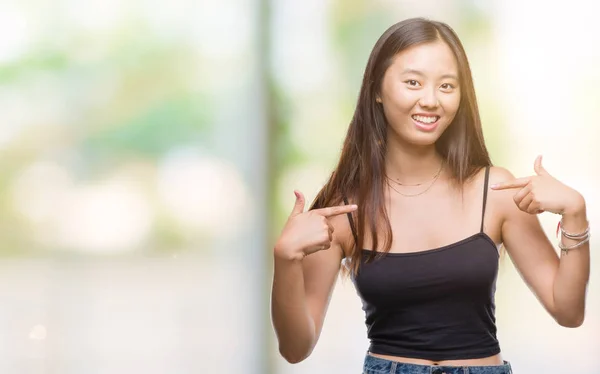 孤立した背景の顔に笑顔と自信を持って 誇りと幸せな指で自分を指して上若いアジア女性 — ストック写真