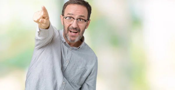 ハンサムな中年エレガントな年配の男性でメガネをかけて分離先驚いて指で指している背景 開く口びっくり式 前方に何 — ストック写真