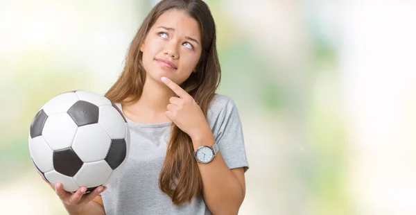 サッカー サッカー ボールに関する質問は 非常に混乱して考え分離背景深刻な顔を考えての上に保持している若い美しいブルネットの女性 — ストック写真