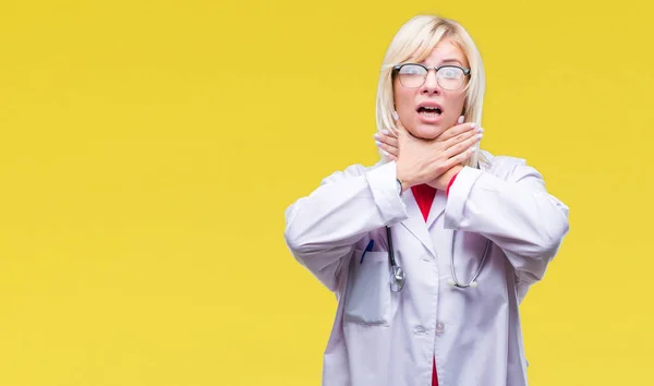 Young beautiful blonde doctor woman wearing medical uniform over isolated background shouting and suffocate because painful strangle. Health problem. Asphyxiate and suicide concept.