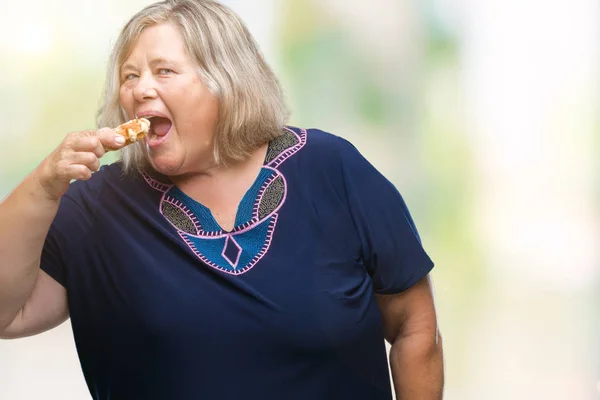 高级加大小白种女人吃华夫饼在孤立的背景下 自信的表情 聪明的脸认真思考 — 图库照片