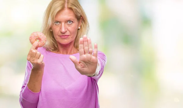 Mulher Loira Meia Idade Comendo Donut Rosa Sobre Fundo Isolado — Fotografia de Stock