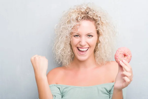 Joven Mujer Rubia Sobre Grunge Gris Fondo Comiendo Rosado Donut —  Fotos de Stock