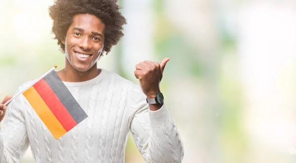 指していると幸せそうな顔を笑顔で側まで親指で示す分離の背景にドイツの国旗をアフロ アメリカ人 — ストック写真