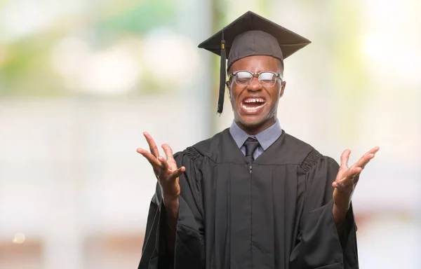 Young graduated african american man over isolated background celebrating mad and crazy for success with arms raised and closed eyes screaming excited. Winner concept