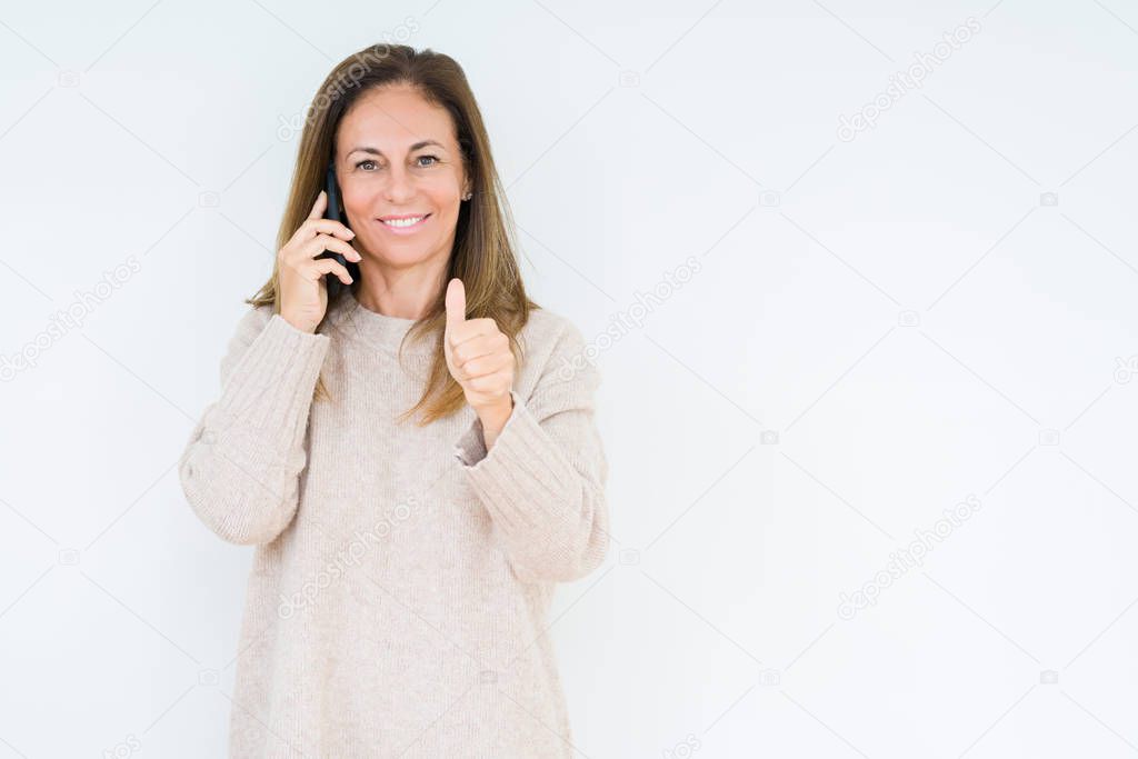 Middle age woman talking on smartphone over isolated background happy with big smile doing ok sign, thumb up with fingers, excellent sign