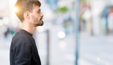 Yakışıklı delikanlı izole arka tarafına, seyir üzerinde dinlenmek doğal yüz emin gülümseme ile pozuyla profili.