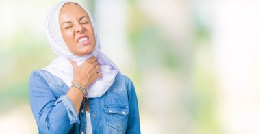 Orta yaş Doğu Arap kadın giyiyor Arap türban izole üzerinde arka plan ağrılı boyun, boğaz gribi, kesek ve enfeksiyon için dokunaklı