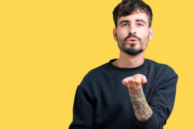 Yakışıklı delikanlı bir öpücük el ile güzel ve seksi olmak hava üfleme kamera bakarak izole arka plan üzerinde. Aşk ifade.