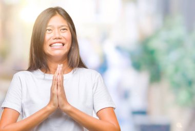 Genç Asyalı kadın dilencilik ve umut ifade yüzünde çok duygusal ve endişe ile birlikte elleriyle dua izole arka plan üzerinde. Bağışlanmak. Din kavramı.