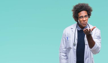 Afro Amerikalı doktor adam izole arka plan bir öpücük el ile güzel ve seksi olmak hava üfleme kamera bakıyor. Aşk ifade.
