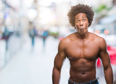 Afro Amerikalı gömleksiz adam çıplak vücut üzerinde gösterilen arka plan yapma balık yüz dudaklı, çılgın ve komik bir jest izole. Komik ifade.
