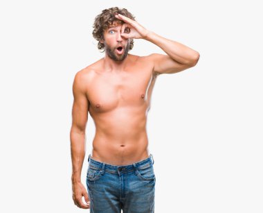 Sürpriz yüz, göz parmaklarının arasından seyir yakışıklı İspanyol modeli adam seksi ve gömleksiz ok jest yapıyor izole arka plan üzerinde şok. İmansız ifade.