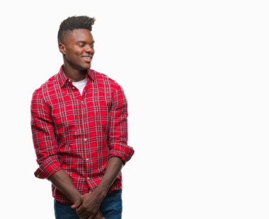 Afrikalı-Amerikalı genç uzak tarafına yüzünde, doğal ifade gülümseme ile seyir izole arka plan üzerinde. Kendine güvenen gülüyor.