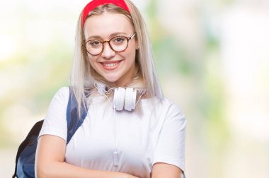 Gözlük ve sırt çantası üzerinde giyen genç sarışın öğrenci kadın mutlu yüz ile gülümseyerek kameraya seyir silah geçti arka plan izole. Olumlu bir kişi.