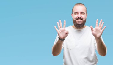 Gösterilen ve parmakları ile işaret izole arka plan üzerinde rahat t-shirt giyen genç beyaz hipster adam numara 9 kendinden emin ve mutlu gülümseyerek süre.