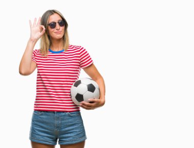 Parmak, mükemmel sembolü ile ok işareti yapıyor izole arka plan üzerinde futbol futbol topu tutan genç güzel kadın