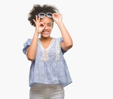 Genç afro Amerikalı kadın gülümsüyor, parmakları ile mutlu yüz üzerinden seyir göz el ile ok jest yapıyor izole arka plan üzerinde gözlük.