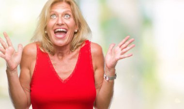 Orta yaş sarışın kadın deli ve silah ile başarı için deli kutluyor izole arka plan üzerinde kaldırdı ve heyecanlı çığlık gözler kapalı. Kazanan kavramı