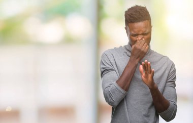 Afrikalı-Amerikalı genç bir şey pis ve iğrenç kokulu izole arka plan, dayanılmaz koku, holding nefes burun parmaklar ile. Kötü kokuyor kavramı.