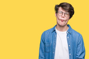 İzole arka plan yapma balık yüzüne dudaklı, çılgın ve komik bir jest gözlük takan yakışıklı delikanlı. Komik ifade.