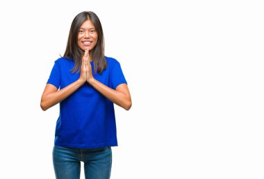 Genç Asyalı kadın birlikte emin gülümseyen bağışlanmak ellerle dua izole arka plan üzerinde.
