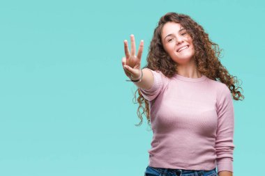 Gösterilen ve parmakları ile işaret izole arka plan üzerinde pembe kazak giyen güzel esmer kıvırcık saçlı Genç kız kendinden emin ve mutlu gülümseyerek iken üçüncü.