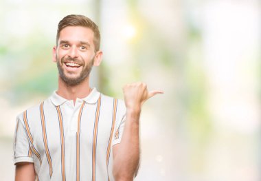 Yakışıklı delikanlı arıyor ve başparmak yanında yukarıyı mutlu yüz ile gülümseyen izole arka plan üzerinde.